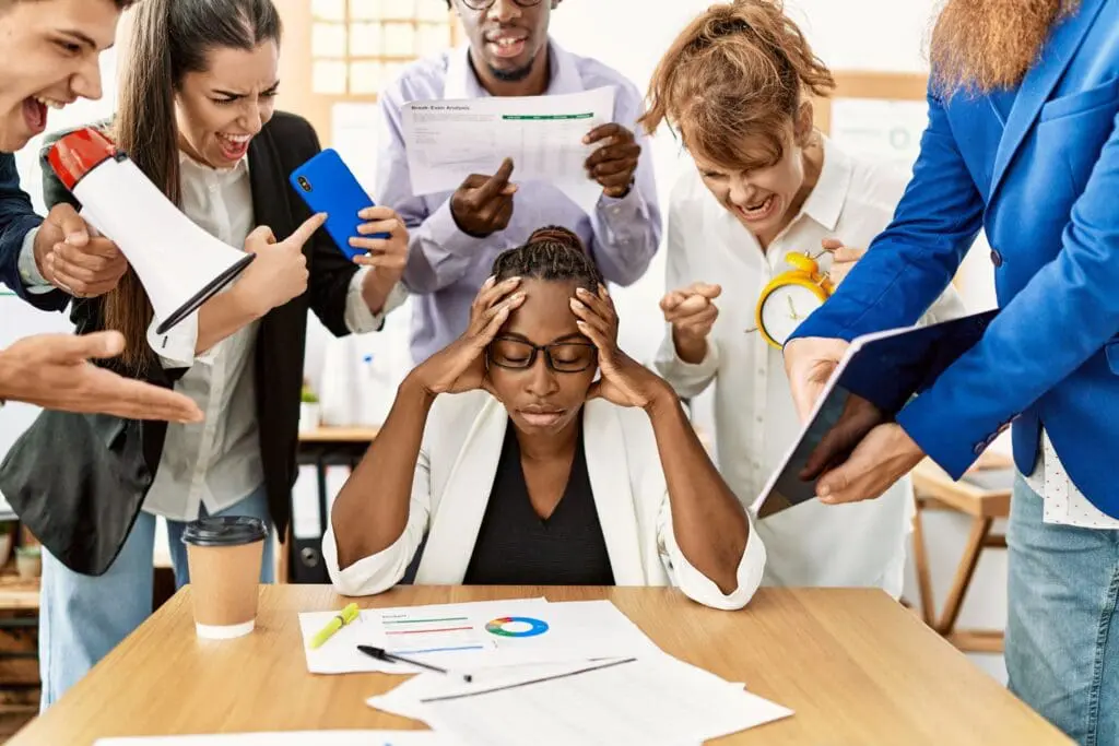 Stressed manager surrounded by demanding employees